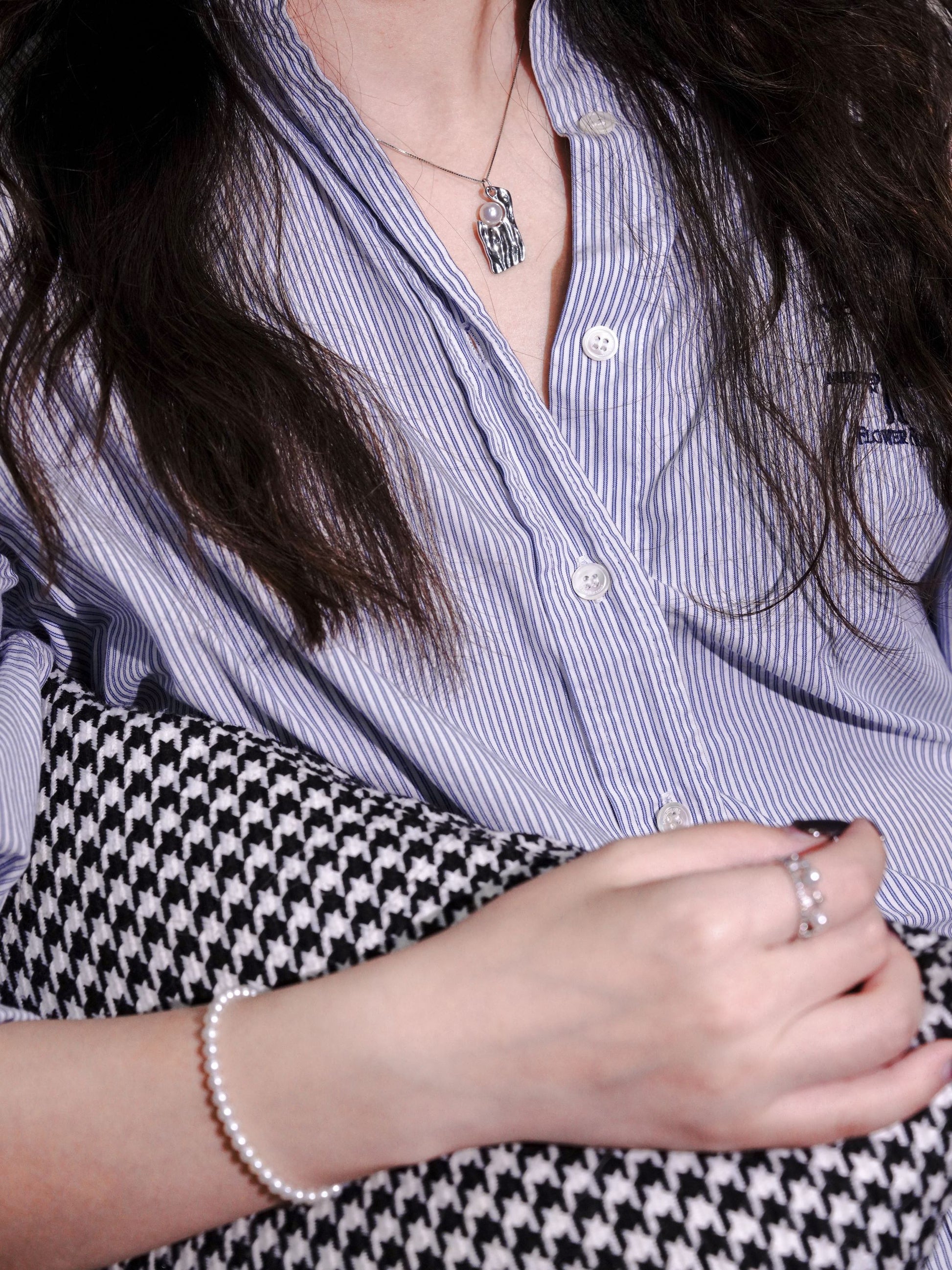Statement silver and pearl necklace seamlessly styled with matching Cyrene pearl bracelets and rings for a cohesive contemporary look.