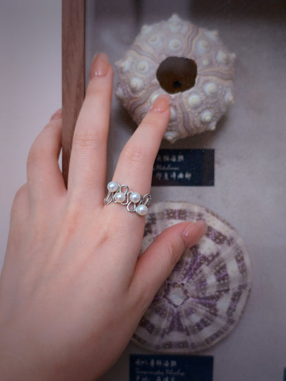 Cyrene Waveset Pearl Ring on hand against natural specimen display — sterling silver and freshwater pearl open ring